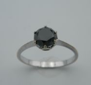 A 9 ct white gold and black diamond solitaire ring, the stone approximately 1.25 carats.