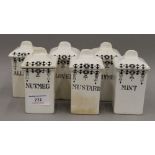 A set of white porcelain spice jars. 11 cm high.