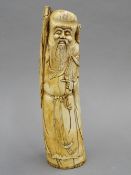 A 19th century Chinese carved ivory figure of Shao Loa, typically modelled holding a staff.