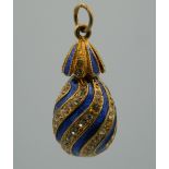 An enamelled decorated silver gilt egg pendant. 2.75 cm high.