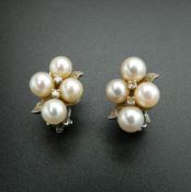 A pair of 14 K white gold pearl and diamond earrings. 1.