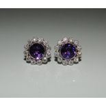 A pair of fine quality 18 ct white gold diamond and amethyst earrings. Each 1.4 cm diameter.