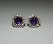 A pair of fine quality 18 ct white gold diamond and amethyst earrings. Each 1.4 cm diameter.