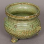 A Chinese celadon glaze porcelain censer, of squat baluster form, with twin mask handles.