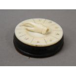 A Victorian ivory mounted whist marker. 4.25 cm diameter.