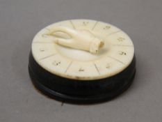 A Victorian ivory mounted whist marker. 4.25 cm diameter.