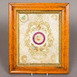 A 19th century silk and cut paper valentine panel, centred with cupid, housed in a burr maple frame.