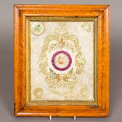 A 19th century silk and cut paper valentine panel, centred with cupid, housed in a burr maple frame.