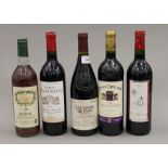 Five bottles of various French red wines