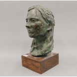 A female patinated bronze bust mounted on a wooden display plinth,