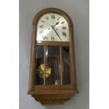 An early 20th century oak wall clock. 72 cm high.