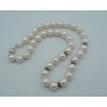 An 18 ct white gold and diamond set string of pearls. 40 cm long.