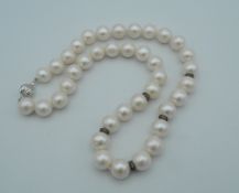 An 18 ct white gold and diamond set string of pearls. 40 cm long.