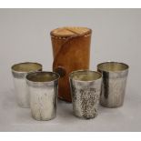 A set of four cased silver shot cups. The case 8 cm high.