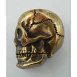 A brass vesta formed as a skull. 4 cm high.