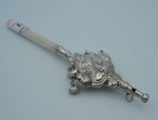 A silver and mother-of-pearl rattle. 18 cm long.
