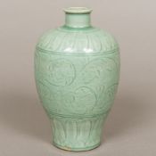 A Chinese porcelain vase, of baluster form, with incised decoration on a celadon ground. 21 cm high.