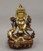 A finely cast part gilded and painted Tibetan copper figure of a seated deity. 22 cm high.