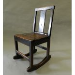 An 18th century oak solid seated rocking chair. 40 cm wide.