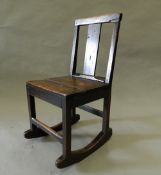 An 18th century oak solid seated rocking chair. 40 cm wide.