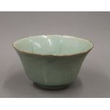 An 18th century Chinese celadon ground bowl with flared segmented body on a circular foot.