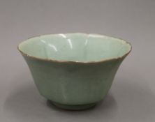 An 18th century Chinese celadon ground bowl with flared segmented body on a circular foot.