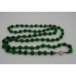 An apple green jade necklace, set with a bi-coloured 18 K gold clasp. 140 cm long.