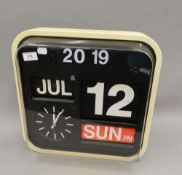 A vintage office calendar clock. 41 cm wide.