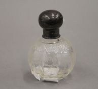 A small silver topped glass scent bottle. 9 cm high.