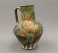 An Antique pottery jug with iridescent glaze and extensive restorations. 28 cm high.