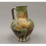 An Antique pottery jug with iridescent glaze and extensive restorations. 28 cm high.