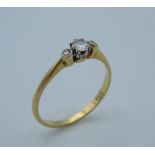 An 18 ct gold three diamond trilogy ring. Ring size T (2.