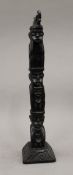 An Eastern carved wooden figural totem pole. 34.5 cm high.