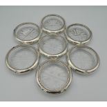 Seven glass and sterling silver rimmed coasters, stamped sterling. Each 9.5 cm diameter.