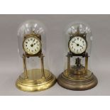 Two brass Anniversary clocks, under glass domes. The largest 30 cm high.