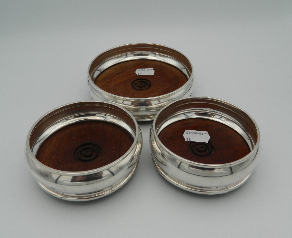 A trio of silver and wood coasters,