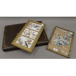 A cased set of Chinese place mats and two silk pictures. The case 40 cm wide.