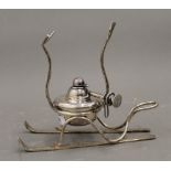 A silver plated Brandy warmer formed as a pairs of skis. 15 cm high.