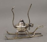 A silver plated Brandy warmer formed as a pairs of skis. 15 cm high.