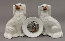 A pair of 19th century pottery Staffordshire spaniels and a child's nursery plate entitled 'May'.