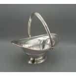 A hallmarked silver pierced oval bon bon dish, with swing handle, Chester 1914. 17 cm wide (4.