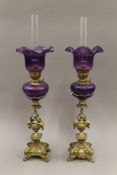 A pair of Victorian brass and purple glass oil lamps. 62 cm high.