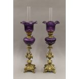 A pair of Victorian brass and purple glass oil lamps. 62 cm high.