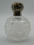 A silver topped cut glass scent bottle. 10 cm high.