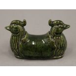 A Chinese green porcelain brush rest. 12 cm wide.