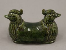 A Chinese green porcelain brush rest. 12 cm wide.