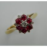 An 18 ct gold ruby and diamond cluster ring. Ring Size N.