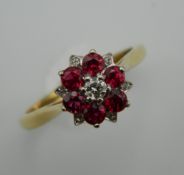 An 18 ct gold ruby and diamond cluster ring. Ring Size N.