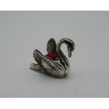 A silver pin cushion in the form of a swan. 2 cm long.