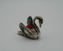 A silver pin cushion in the form of a swan. 2 cm long.